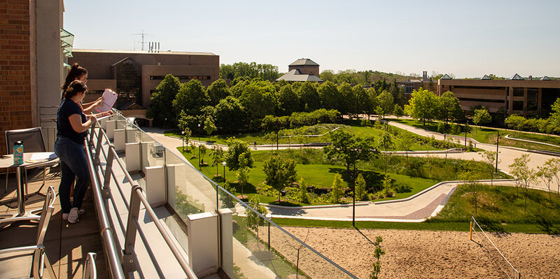 Two researchers observe and record site use on the University of Michigan North Campus