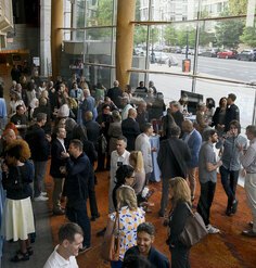 Looking down on a crowd of reception attendees in the glass-sided lobby of the theater