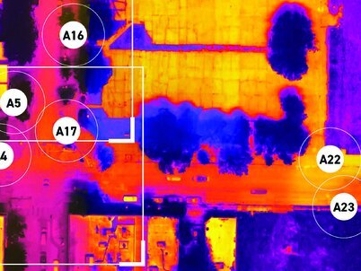 An arial view of a neighborhood with an infrared overlay showing hotter and cooler spots